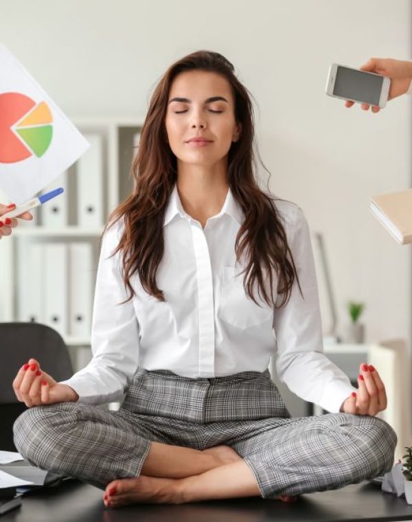 Businesswoman with a lot of work to do meditating in office